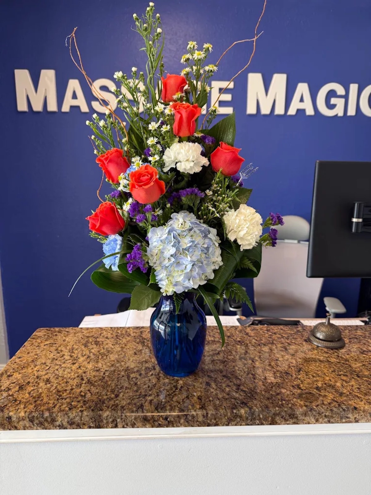 A vase of flowers on the Massage Magic front desk.